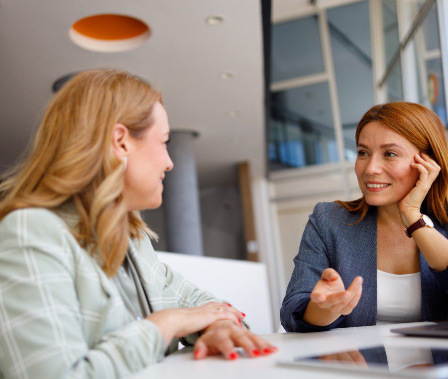 Two women having a friendly conversation indoors.